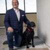 AmeriVet CEO Thomas Thill, pictured kneeling with his dog Ace in an office under construction