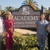veterinary team standing in front of animal hospital sign