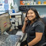 team member holding a phone to their ear and smiling