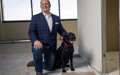 AmeriVet CEO Thomas Thill, pictured kneeling with his dog Ace in an office under construction