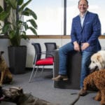AmeriVet CEO Thomas Thill, pictured in his office with five dogs