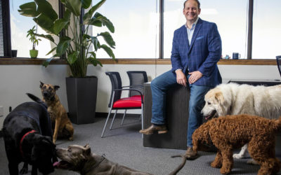 AmeriVet CEO Thomas Thill, pictured in his office with five dogs
